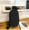 Detail of waterproof matte nylon crossbody bag on a wooden table with lifestyle props - Black