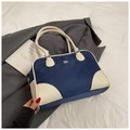 Bolso bowling azul y blanco con detalles de cuero y logo de metal sobre fondo de blazer - Azul Sin Colgante