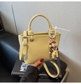 Detalle del bolso tipo cubo en cuero granulado amarillo con logo y adorno lindo - Con Colgante / Amarillo