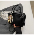 Detalle de bolso tipo cubo negro con grano de lichi, asas redondas y colgante de perla - Con Colgante / Negro