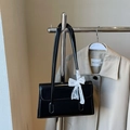 Black glossy rectangle flap shoulder bag with white lace bow charm on a trench coat - No Pendant / Black