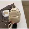 Détail du mini sac à dos crème en cuir grainé avec une fermeture éclair argentée - Blanc Cassé