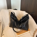 Grande borsa tote nera intrecciata minimalista con tracolla sottile e design morbido - Nero
