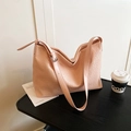 Borsa tote rosa con trama intrecciata e tracolla regolabile su tavolo in legno - Rosa