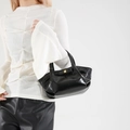 Sac moto en cuir PU brillant noir avec boucles dorées porté comme sac à bandoulière chic - Noir