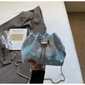 Close-up of light blue bucket bag featuring 3D butterfly appliqués and silver chain strap - Blue Crossbody