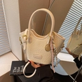 Schicke cremefarbene Flecht-Beuteltasche mit goldenen Details und Tennisanhänger - Mit Anhänger / Gebrochenes Weiß