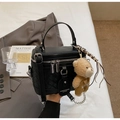 Detailansicht der gewebten schwarzen Koffer-Handtasche mit silberner Hardware - Mit Anhänger / Schwarz