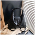 Detail of black PU leather backpack with star patch and buckle on white blazer background - Black