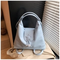 Detail view of light blue nylon backpack showing star stitching and toggle closure - Blue