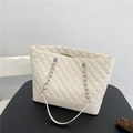 Dettaglio della trama trapuntata beige in ecopelle e catena argentata della borsa - Beige