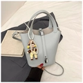 Détail du sac seau bleu-gris à grain de litchi avec fermoir argenté et breloque perle - Bleu avec Pendentif