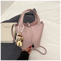 Détails du sac seau rose en cuir grainé avec fermoir métal et chaîne de perles - Rose avec pendentif