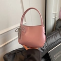 Rosafarbene minimalistische Eimertasche aus mattem Leder mit Herz-Schleifen-Anhänger - Mit Schleifenanhänger / Rosenrosa