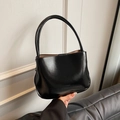 Schicke schwarze Beuteltasche mit Glanzeffekt und hellbraunem Futter in der Hand - Ohne Anhänger / Schwarz