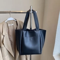 Minimalist black tote bag with large front pocket and matte leather finish for commuting - Black