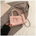 Detailed view of pink crossbody bag with leather bow, silk scarf and gold bell - Pink with Pendant