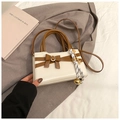 Detail of cream crossbody bag with brown trim, leather bow, and silk scarf charm - Beige With Charm