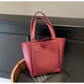 Detalle de bolso tote de cuero sintético rojo oscuro con bolsillo frontal en escena elegante - Burdeos