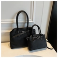 Detail view of black pleated tote bags in two sizes with metallic buckle and leather texture - Large / Black