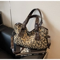 Macro detail of leopard print canvas tote with brown faux leather handles and silver rivets - Leopard Coffee