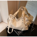 Detail of cream tote bag featuring pebbled leather texture and metal rivet accents - Off-white