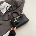 Minimalistische schwarze Handtasche aus Leder mit silbernem Verschluss und Herzanhänger - Schwarz mit Anhänger