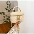 Detailansicht der cremefarbenen Stepptasche mit goldenen Details und Kettenriemen - Gesteppter Box-Stil / Gebrochenes Weiß