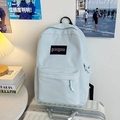 Mochila azul claro minimalista de gran capacidad sobre una maleta para viaje y escuela - Azul