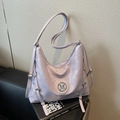 Borsa hobo viola chiaro in pelle lucida a pieghe con logo M argento sul divano nero - Viola
