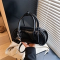 Retro black patent leather bowling bag with heart chain charm in elegant hand-held pose - Black