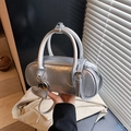 Chic silver metallic bowling bag with top handles and heart charm in a handheld view - Silver