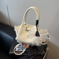 Chic cream woven leather bucket bag with a large white floral charm and metal clasp - Off White
