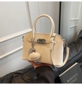 Detalle de bolso en cuero granulado crema con colgante de corazón y cierre giratorio plata - Con Colgante / Blanco Roto