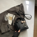 Black litchi grain bucket bag with checkered bow and pearl charm on a grey suit jacket - Black with Pendant