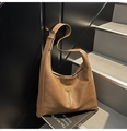 Detail van de karamelkleurige hobo tas met geplooid leer en driehoekig metalen logo - Khaki