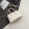 Elegante beige handtas met lychee leertextuur, ronde handvatten en een schouderriem - Zonder hanger / Broken Wit
