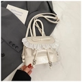Close-up of cream white ballet style backpack featuring lace trim and a delicate bow detail - White