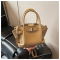Detail view of khaki lychee leather texture and silver buckle on bucket bag - Khaki