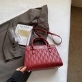 Detailansicht der roten Handtasche mit Rautenprägung und eleganten goldenen Beschlägen - Rotes Dreiecksmuster