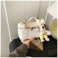 Close-up of white lychee leather vanity bag with a cute puppy plush charm detail - White with Pendant