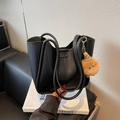 Minimalistische schwarze matte Beuteltasche mit einem süßen braunen Plüschmonster - Schwarz