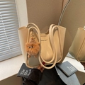 Schicke beige Tragetasche aus glattem Leder mit lustigem Plüschanhänger und Spiegelakzent - Gebrochenes Weiß