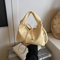 Schicke cremegelbe Eimertasche mit Schleifendetail und rundem Tragegriff oben - Milchgelb