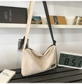 Detail of beige nylon crossbody bag featuring zipper closure and adjustable black shoulder strap - Off White