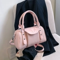 Sac Boston rose élégant avec textures contrastées et détails de clous argentés chic - Rose