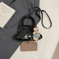 Bolso de mano minimalista en cuero negro con forma de concha y colgante de oso peluche - Con Colgante / Negro
