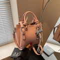 Sac seau en cuir grainé rose avec breloque nœud argenté et ruban rayé sur l'anse - Rose avec pendentif