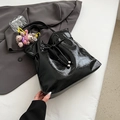 Borsa tote nera lucida plissettata con fiocco a coulisse e ciondolo orsetto morbido - Nero con ciondolo