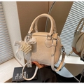 Dettaglio della borsa Boston color crema con ciondolo a cuore e fiocco elegante - Con Ciondolo / Bianco avorio